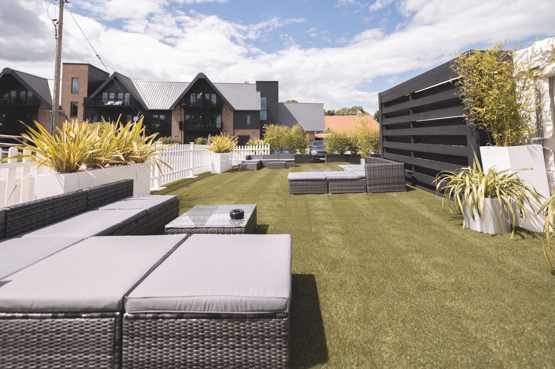 Stylish outdoor event space at Cave Hotels with modern seating and lush greenery.