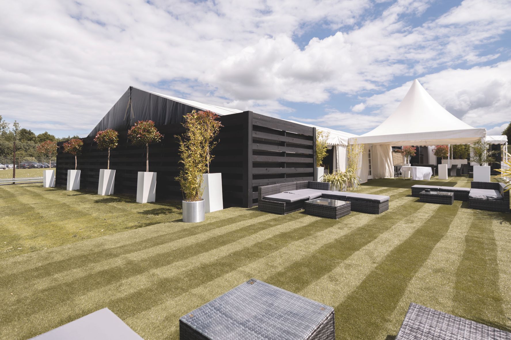 Outdoor event space with sleek black tent and white marquee at Cave Hotels Resort.