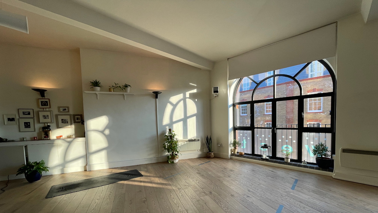 Bright event space at Yoga West with large windows, perfect for workshops and gatherings.