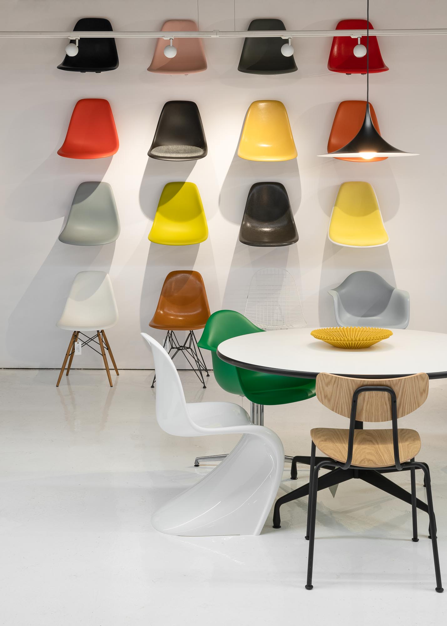 Modern meeting space with round table and colorful chairs for collaborative workshops.