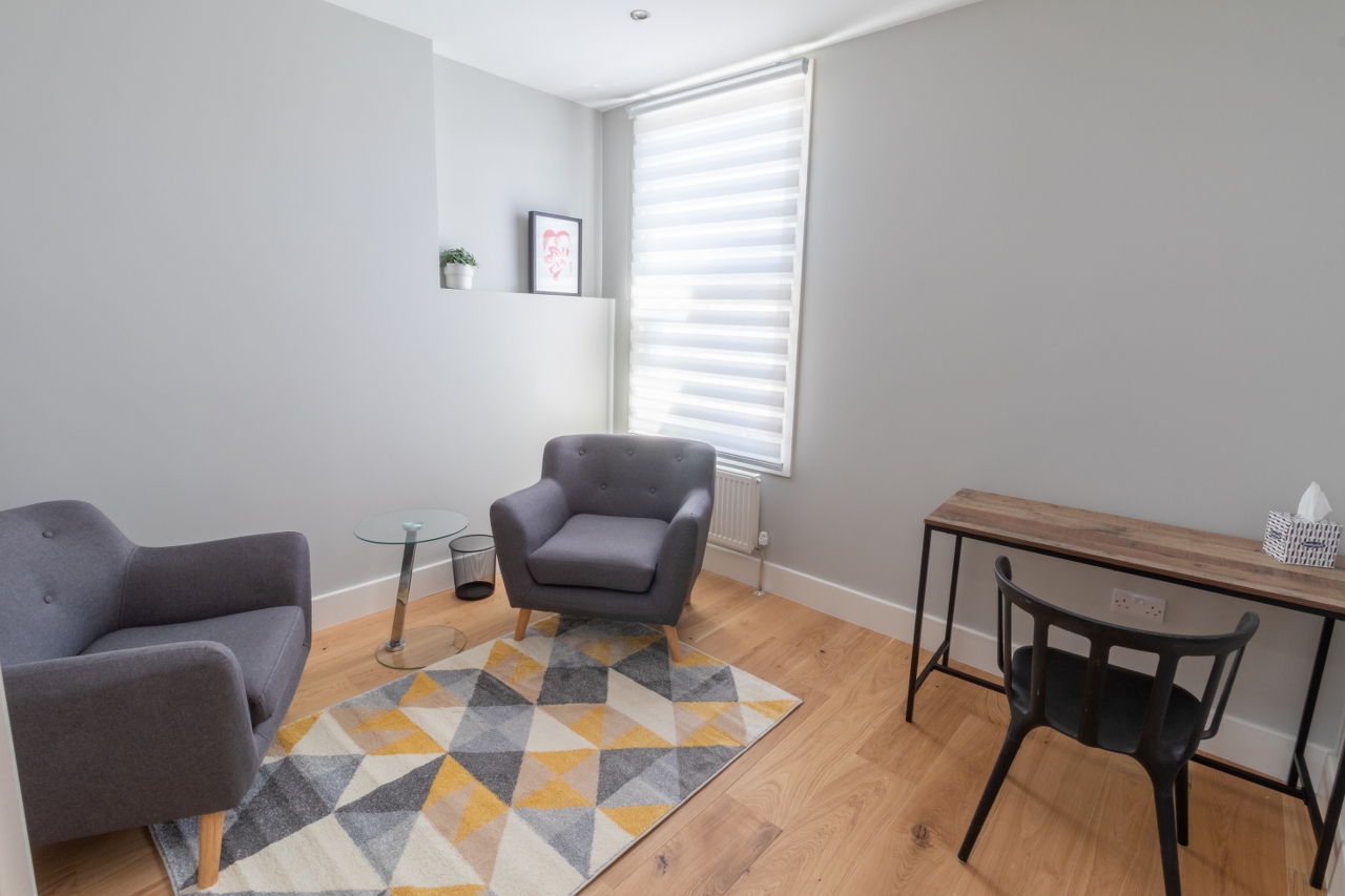 Cozy therapy room with glass table for intimate discussions and brainstorming sessions.