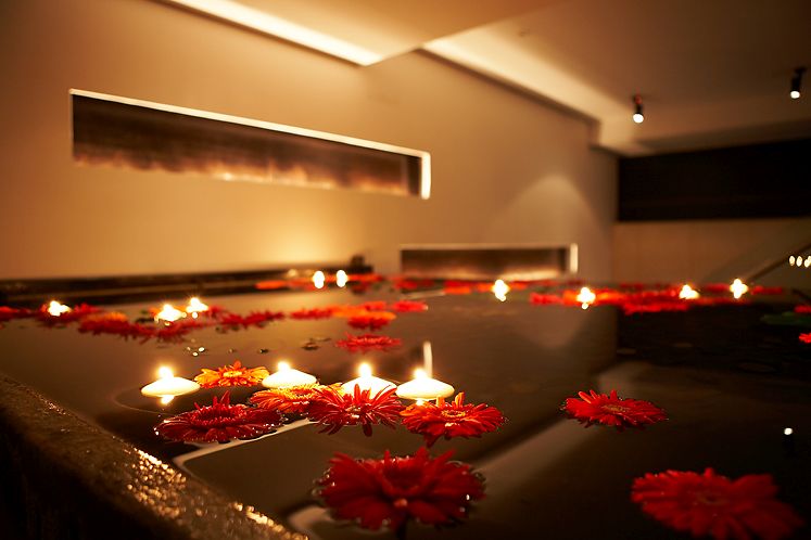 Serene spa setting at Benares Restaurant with floating candles for wellness retreats.