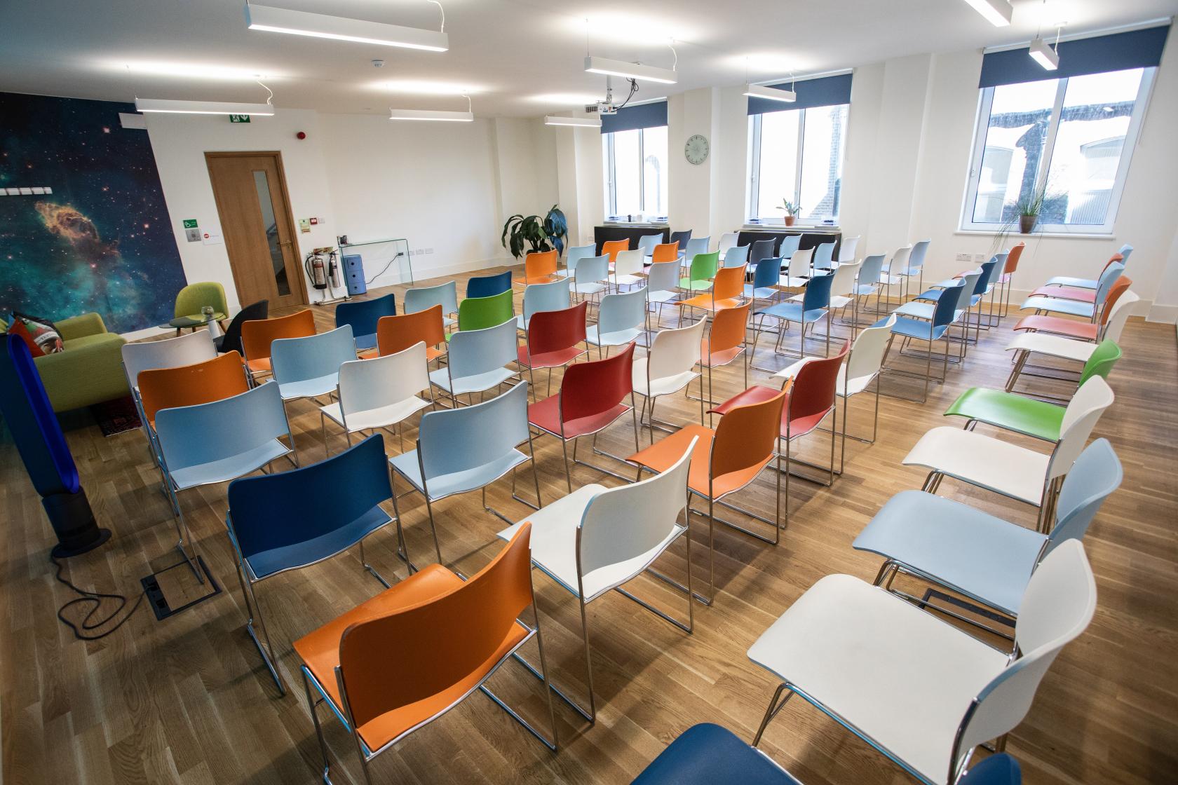 Apollo meeting space with colorful chairs for engaging discussions and presentations.