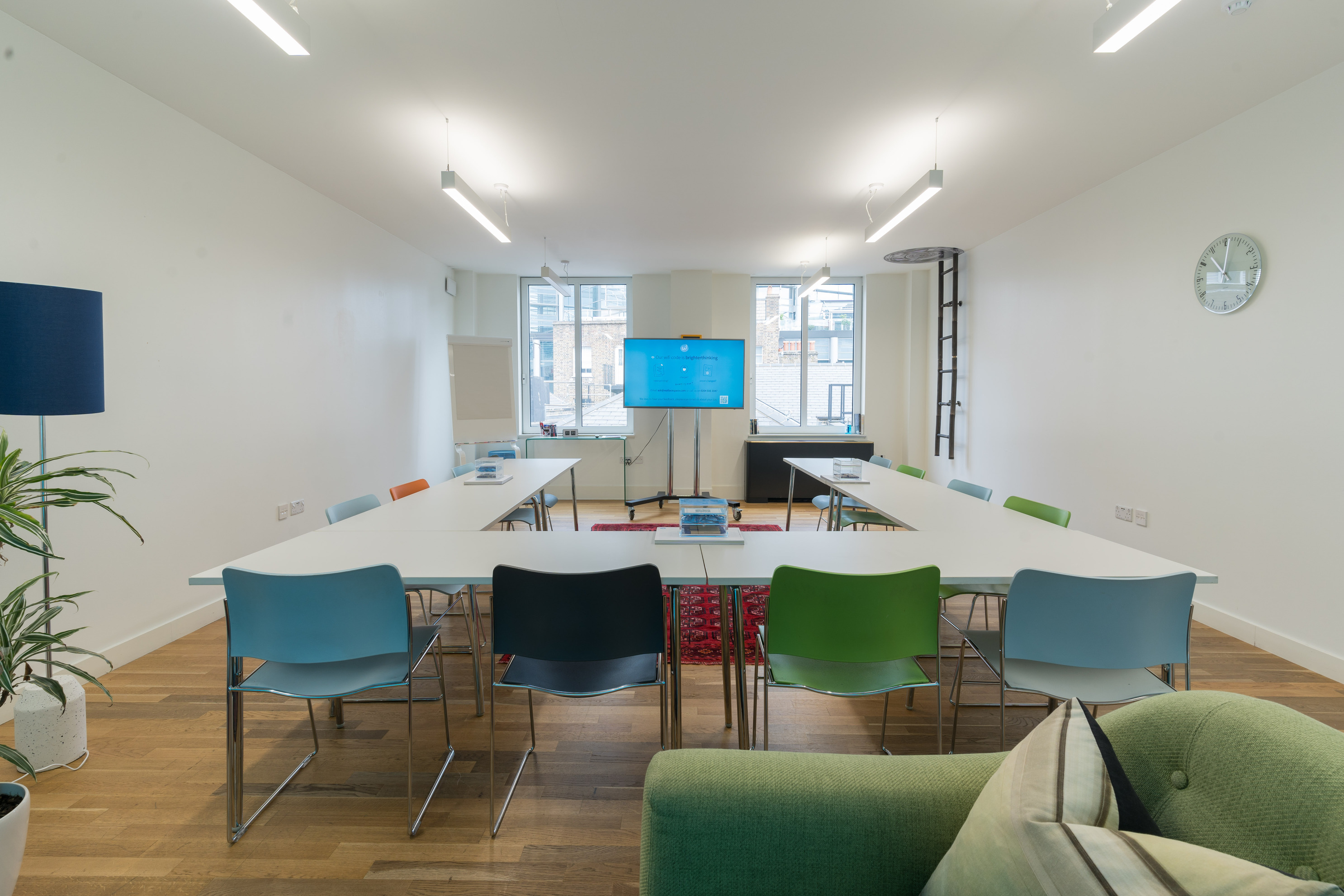 Modern meeting room with colorful chairs, ideal for workshops and brainstorming sessions.