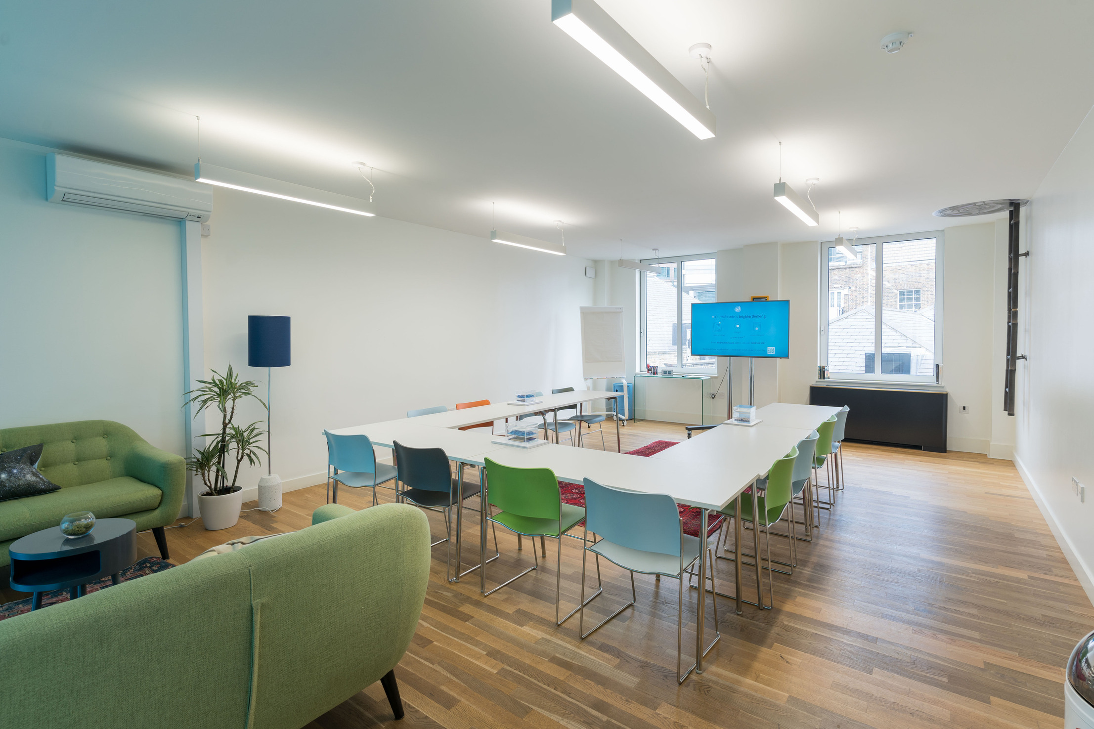 Modern meeting room with colorful chairs, ideal for workshops and brainstorming sessions.