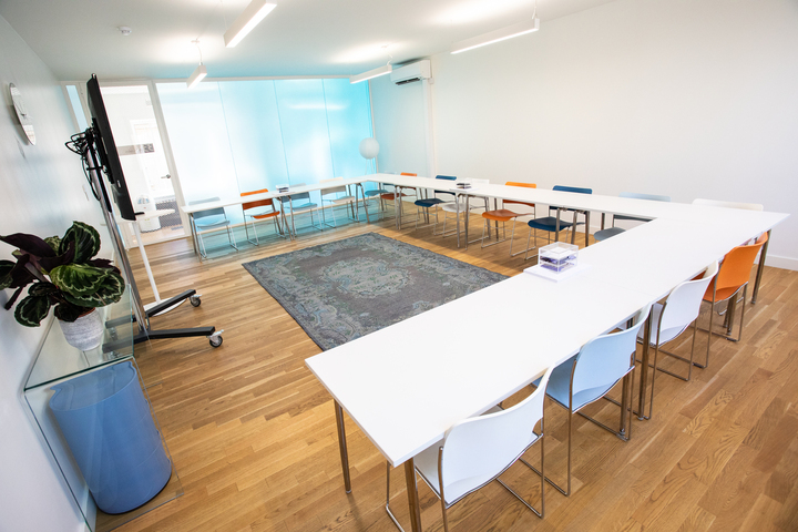 Modern meeting room with colorful chairs, ideal for workshops and brainstorming sessions.