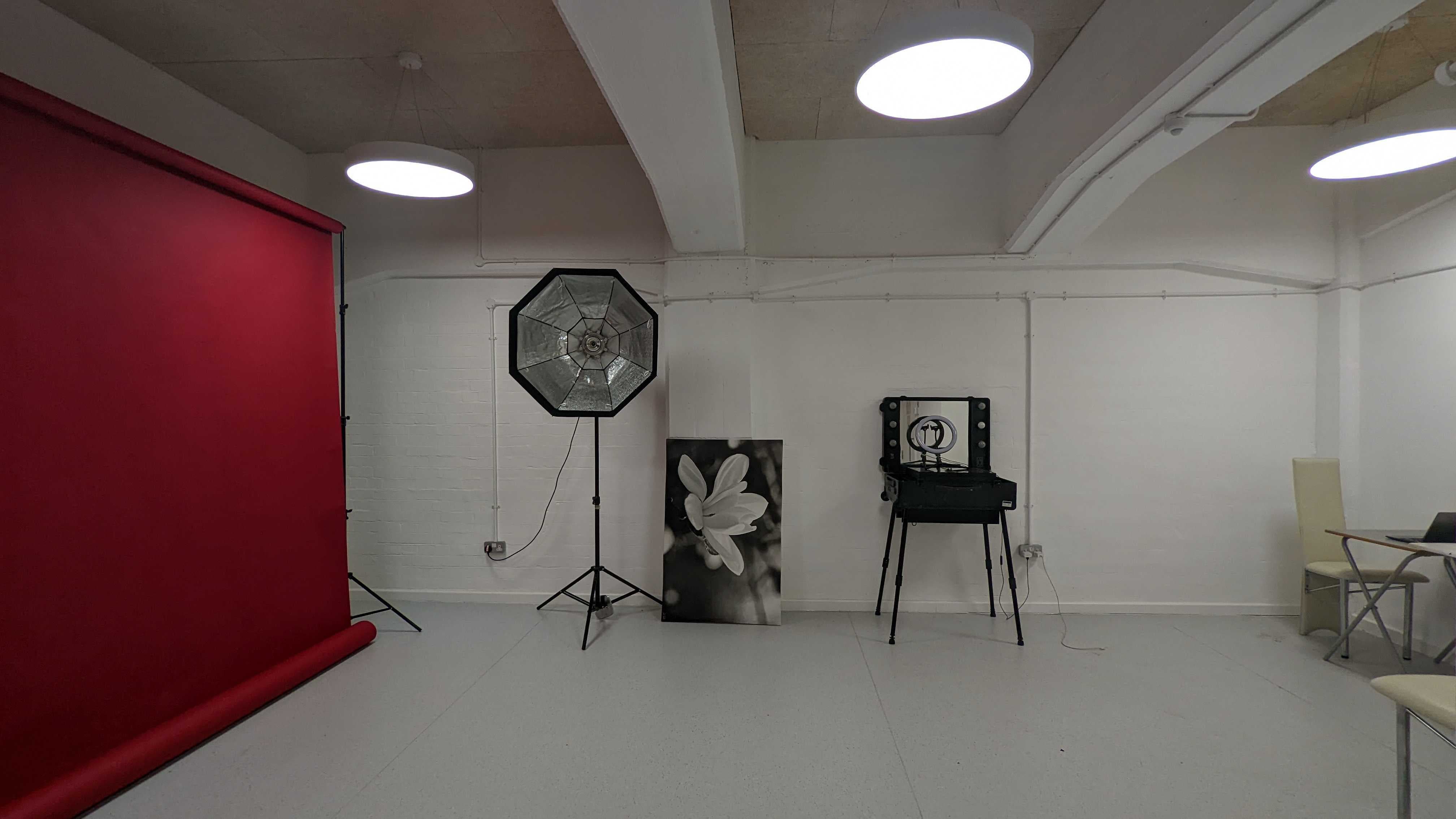 Vision Wharf Studios event space with red backdrop, ideal for workshops and creative presentations.