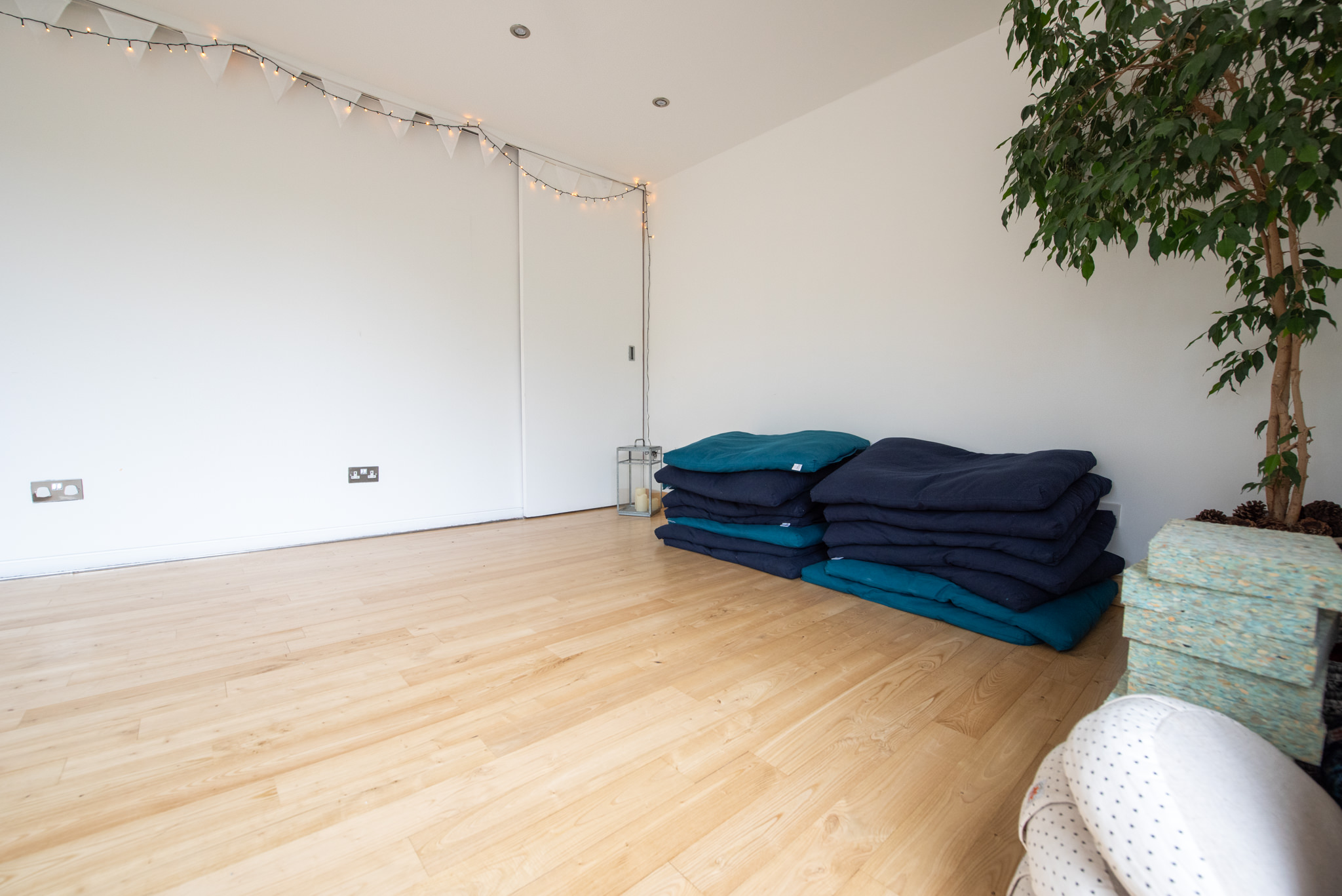 Minimalist event space with cushions and soft lighting for cozy gatherings or workshops.