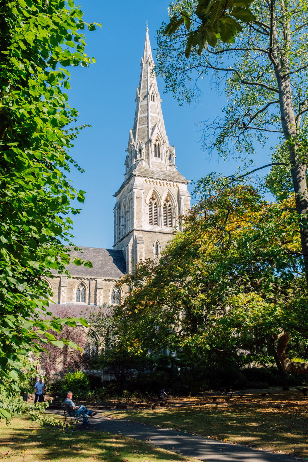 St Giles Church tower amidst greenery, perfect for weddings and outdoor events.
