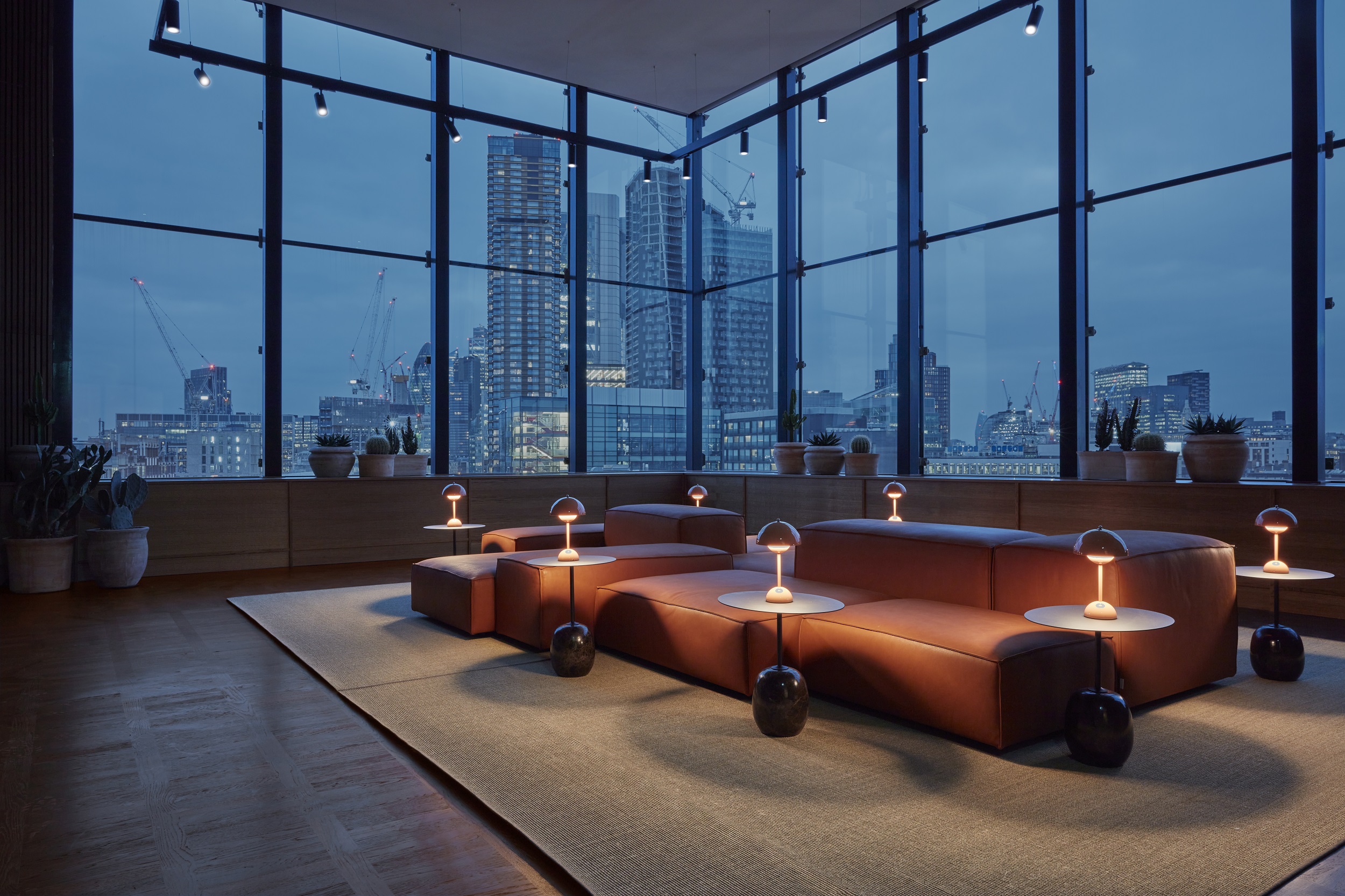 Stylish lounge at One Hundred Shoreditch Hotel with city skyline view, ideal for events.