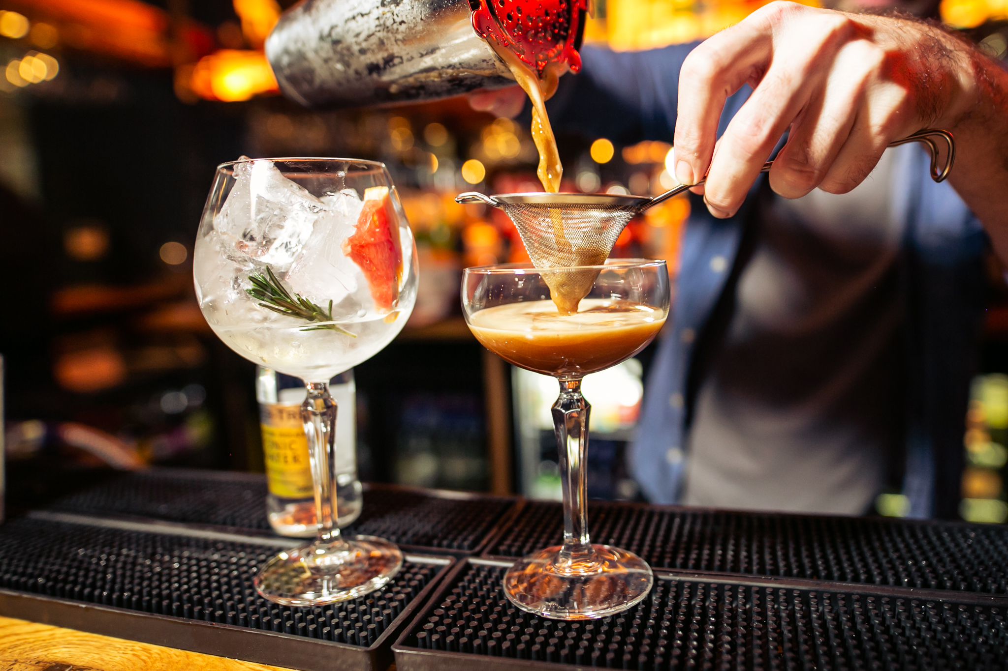 Bartender crafting cocktails with elegant glassware at The Black Horse, London event.