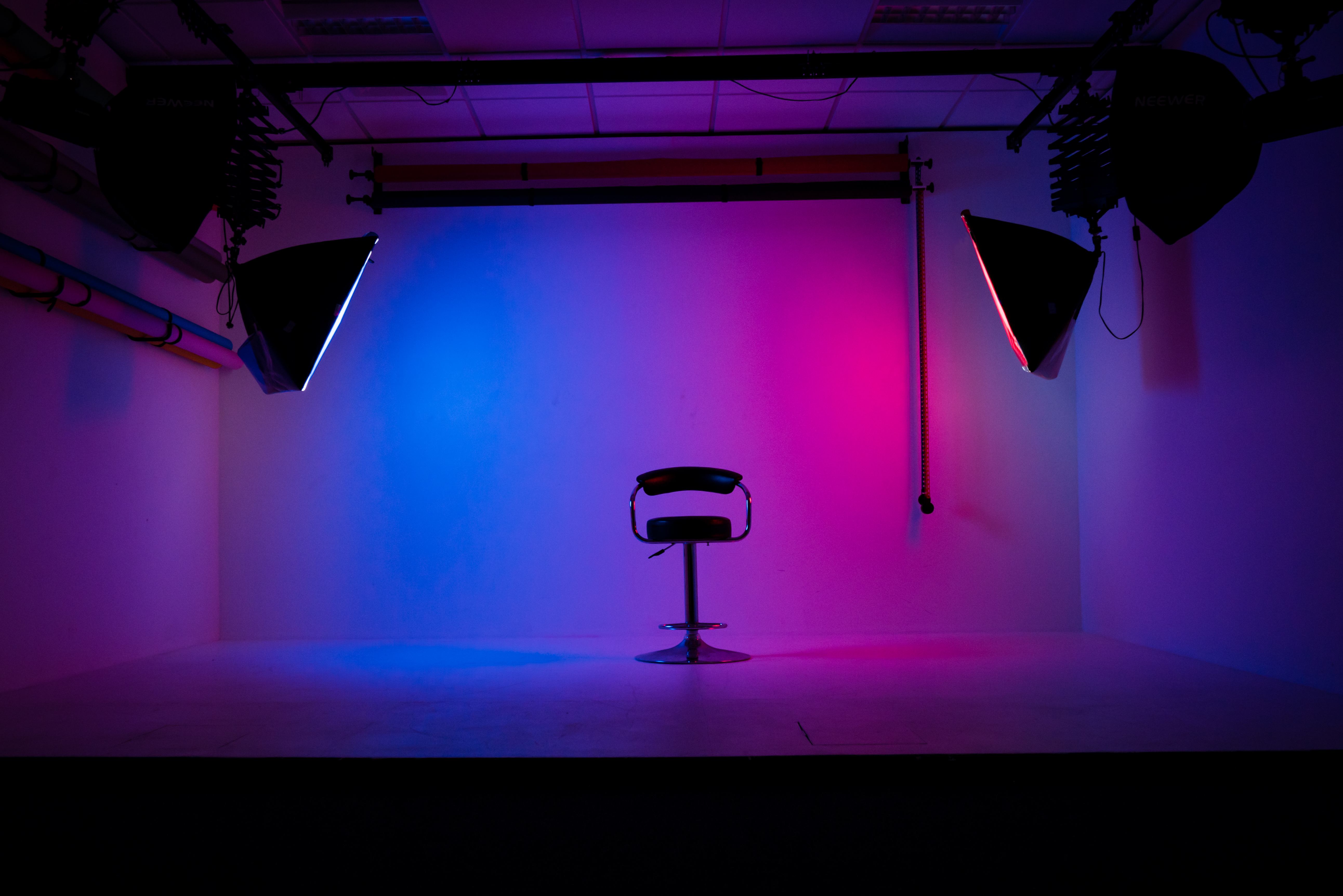 Minimalist film studio setup with vibrant backdrop for modern events and interviews.