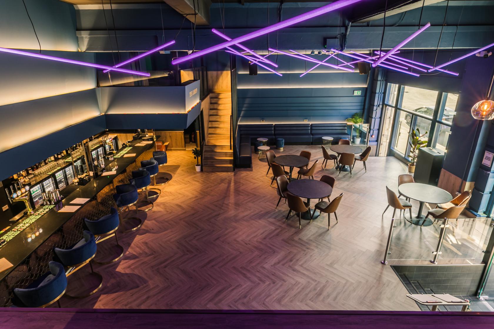 Modern event space at The Camden with stylish seating and vibrant purple lighting.