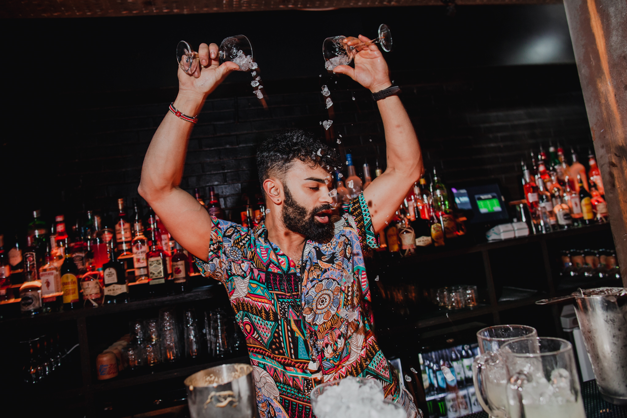 Flair bartender in colorful attire at The Cocktail Club Cardiff event.