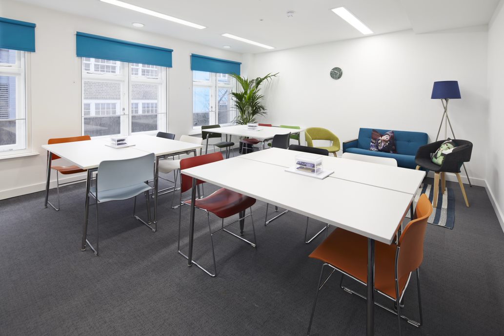 Modern meeting room with colorful chairs, ideal for workshops and brainstorming sessions.