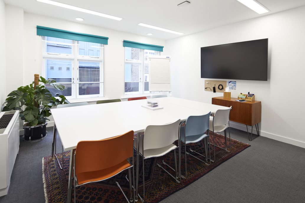 Modern meeting room with spacious table and colorful chairs for productive events.