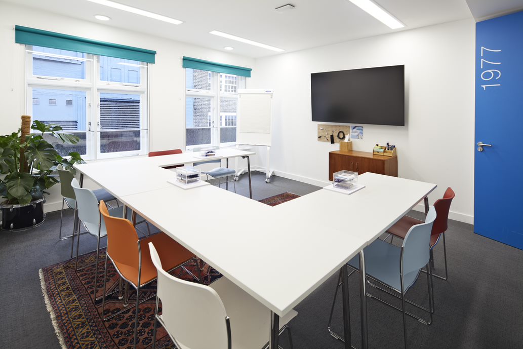 Modern meeting room with U-shaped table, ideal for workshops and brainstorming sessions.