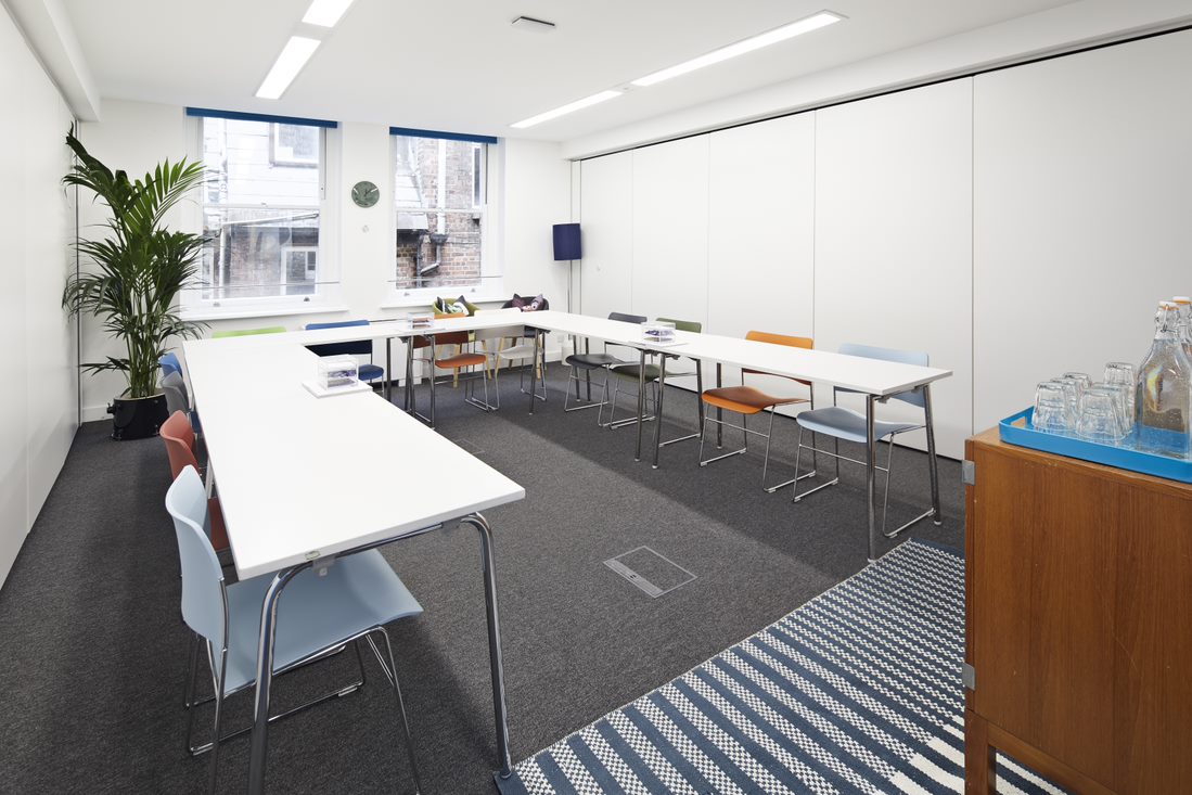 Meeting room with colorful chairs, natural light for collaboration in Covent Garden.