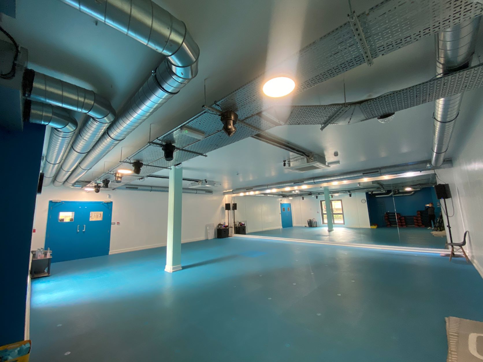 Modern gym event space with blue accents, perfect for workshops and gatherings.