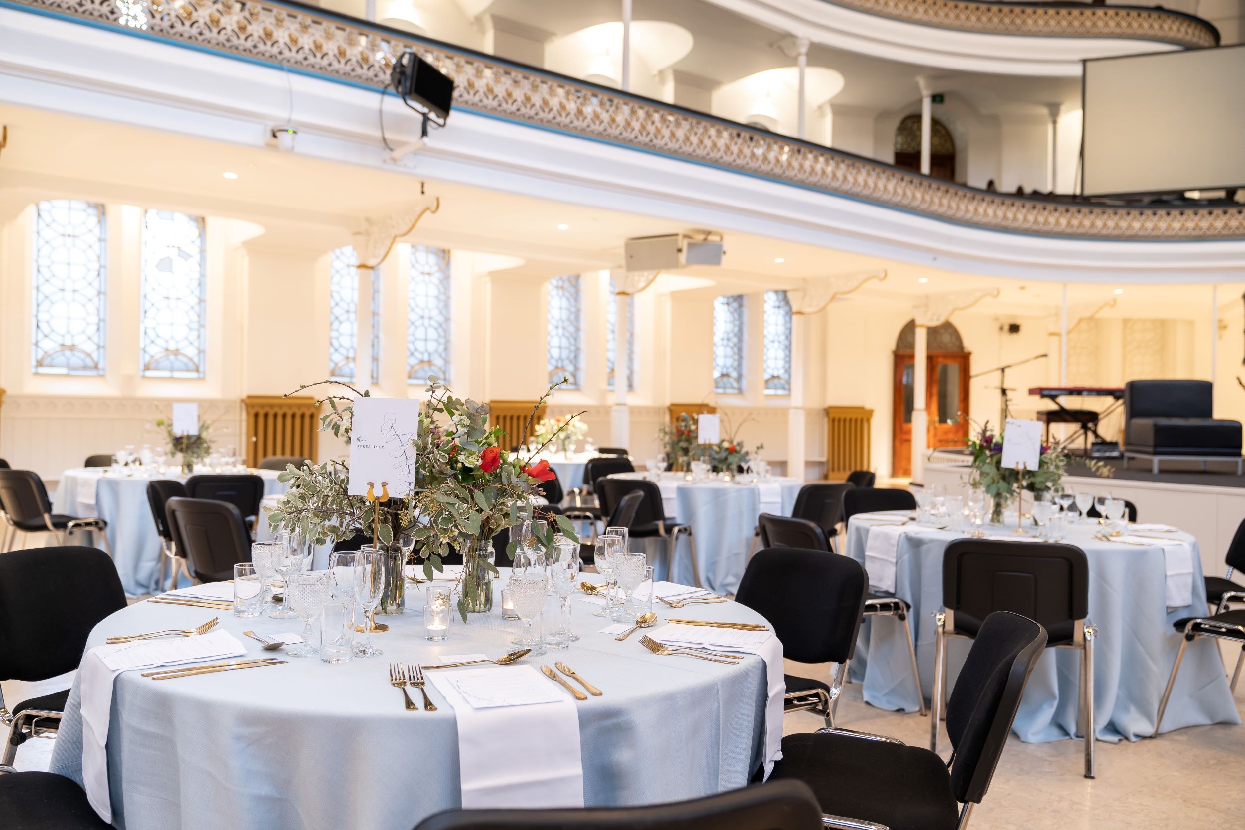 Elegant event space in Westminster Chapel with light blue tables for banquets and corporate events.