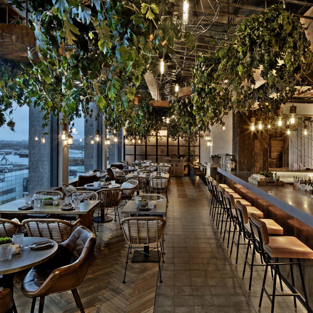 Stylish event space at Treehouse London with lush greenery and warm lighting.