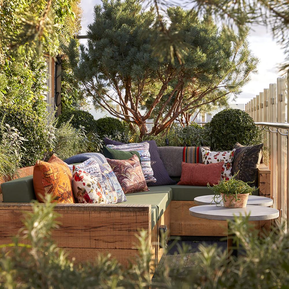 Outdoor lounge at The Nest Treehouse with vibrant cushions for networking events.