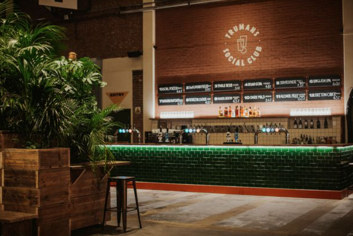 Stylish event space bar with greenery, ideal for social gatherings and networking.