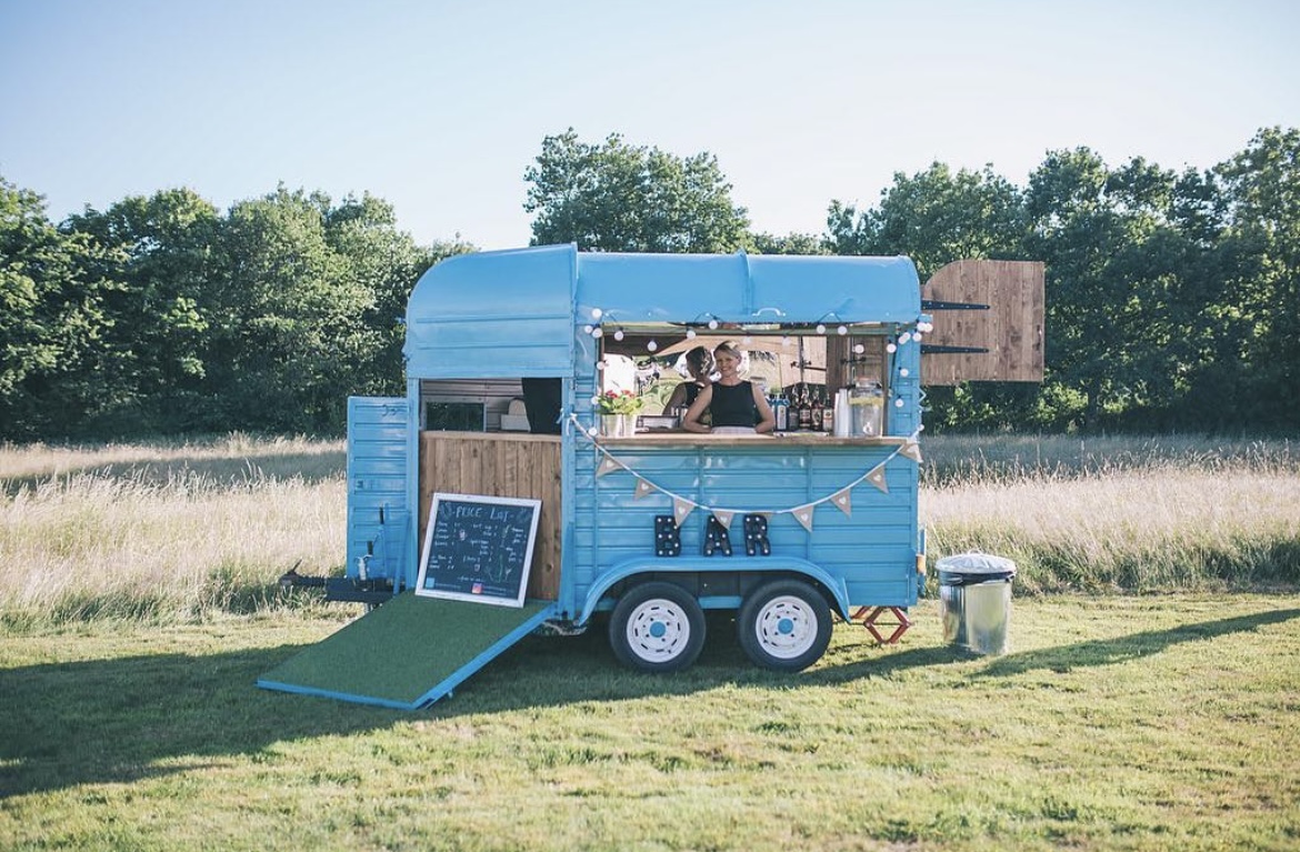 Charming blue mobile bar setup for outdoor weddings and events at Church Farm Estate.