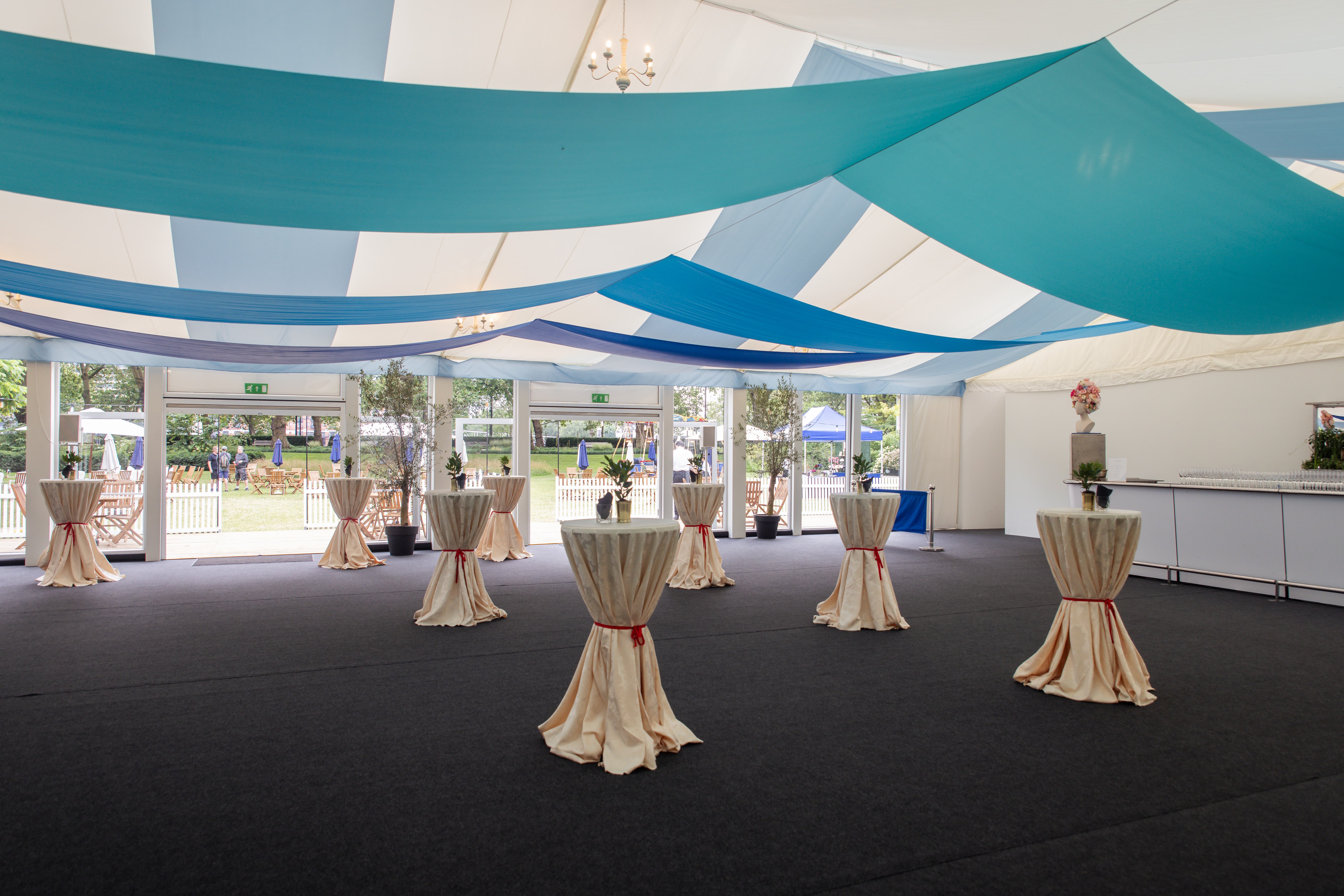 Marquee garden venue for corporate networking reception with elegant ceiling draping.