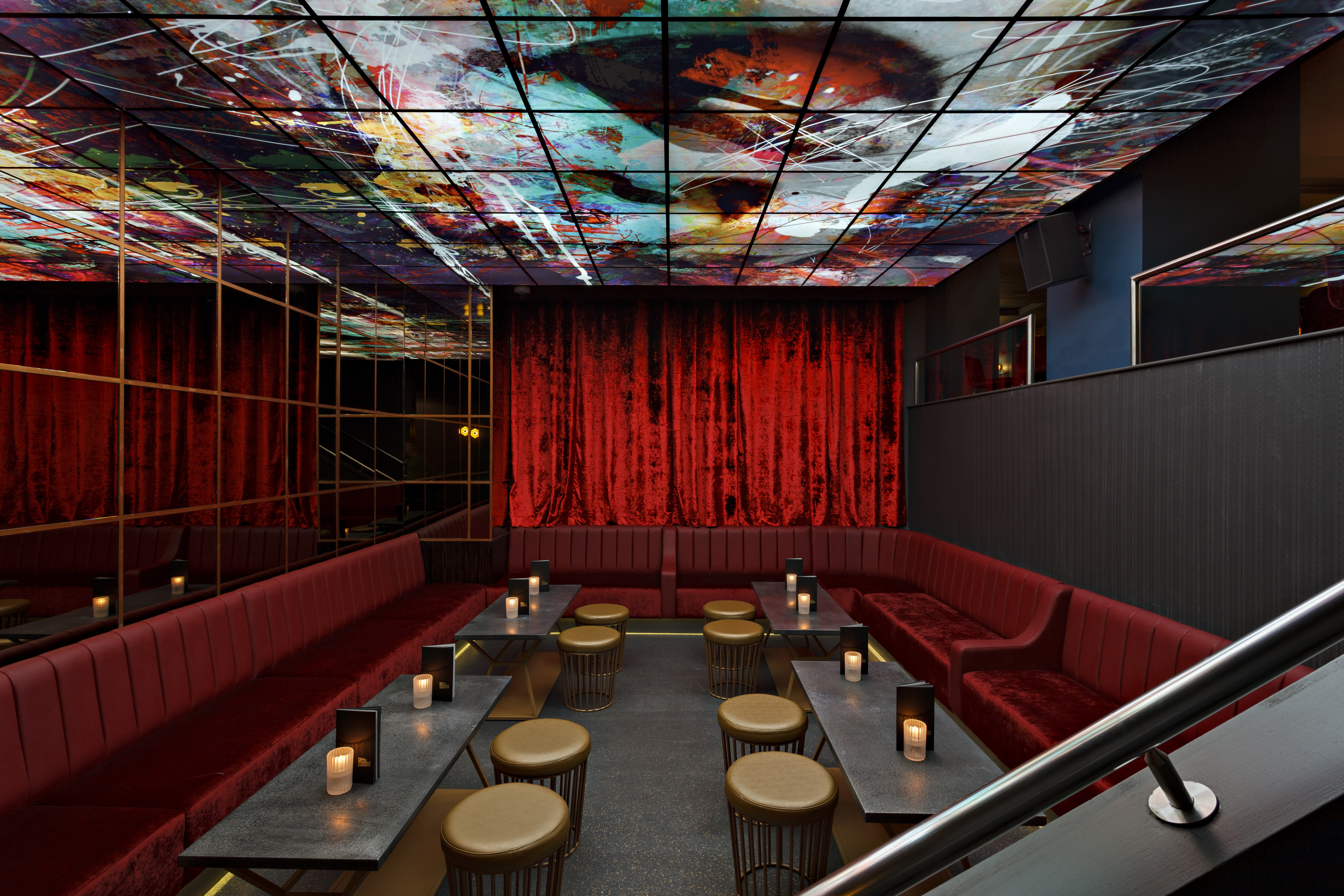 Stylish event space at The Martini Den with plush red seating, perfect for gatherings.