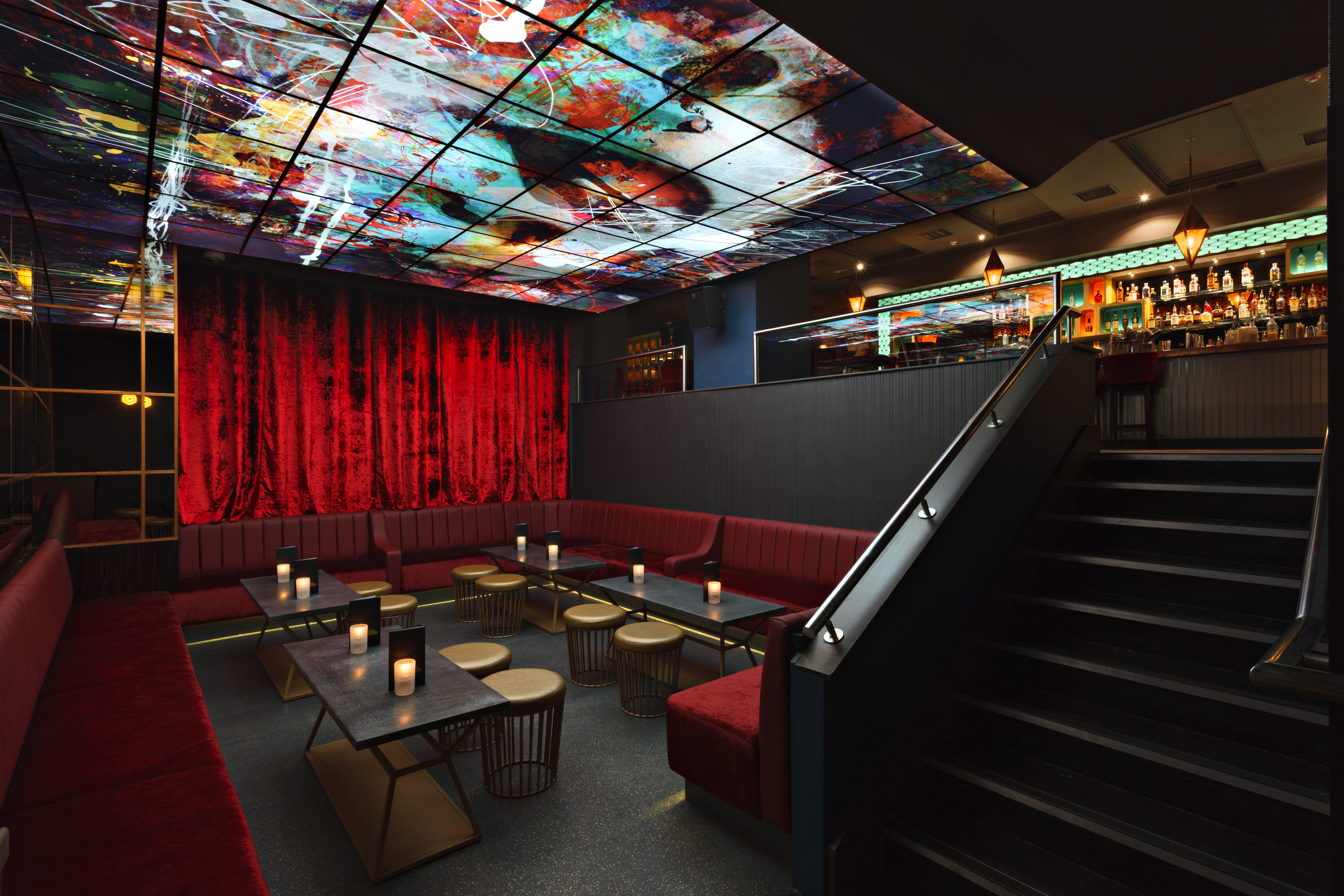 Stylish event space at The Martini Den with vibrant ceiling art, ideal for cocktail receptions.