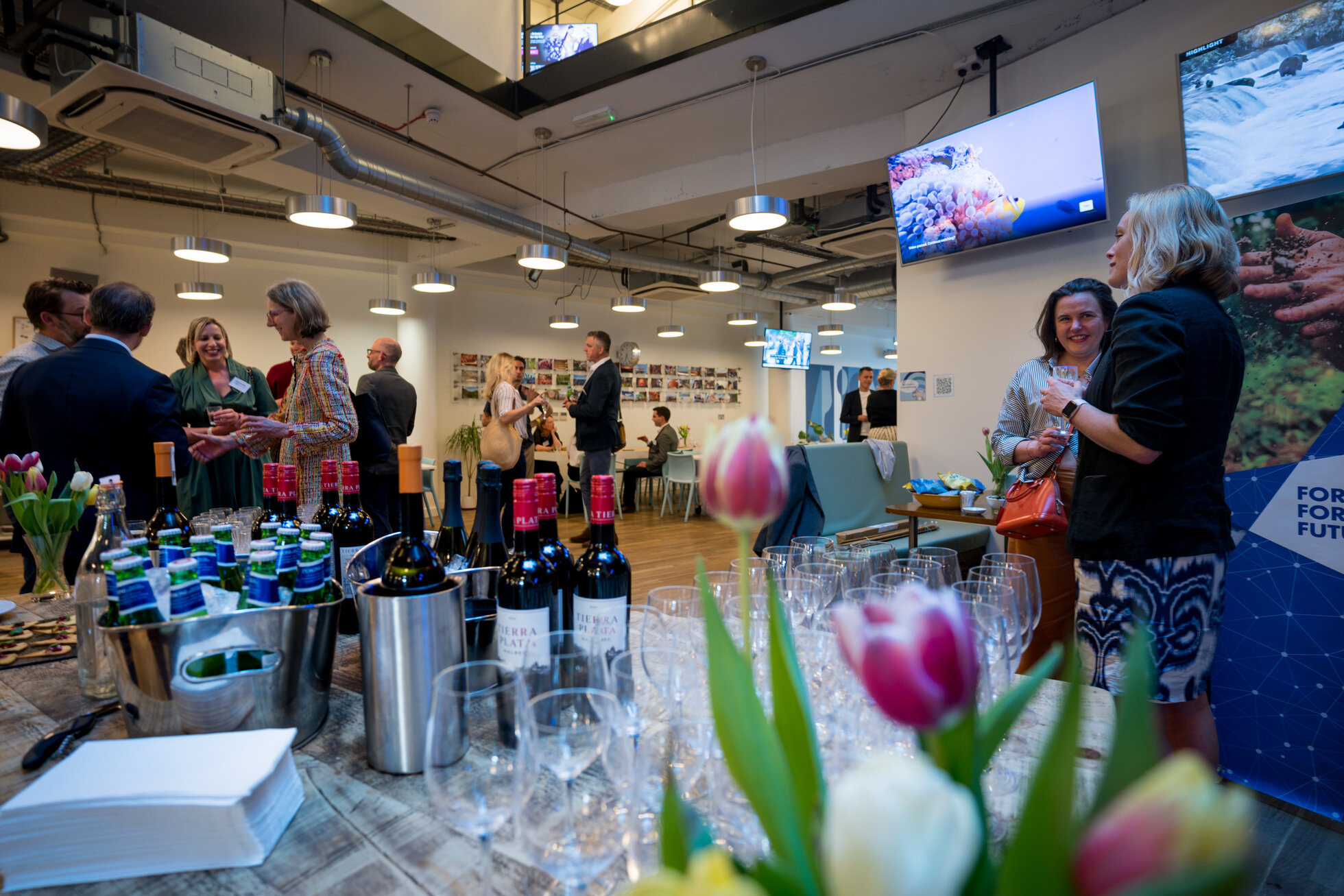 Vibrant networking event at Clerkenwell Kitchen with elegant tables and floral centerpieces.