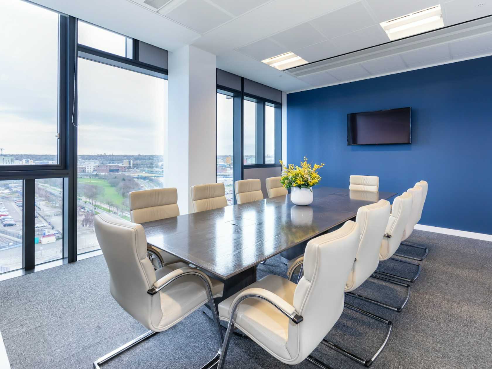 Modern boardroom at EH Woolwich with natural light, ideal for executive meetings and conferences.