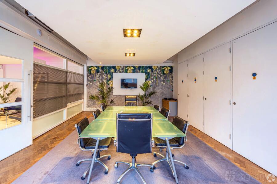Modern boardroom with glass table for strategy sessions and professional client presentations.