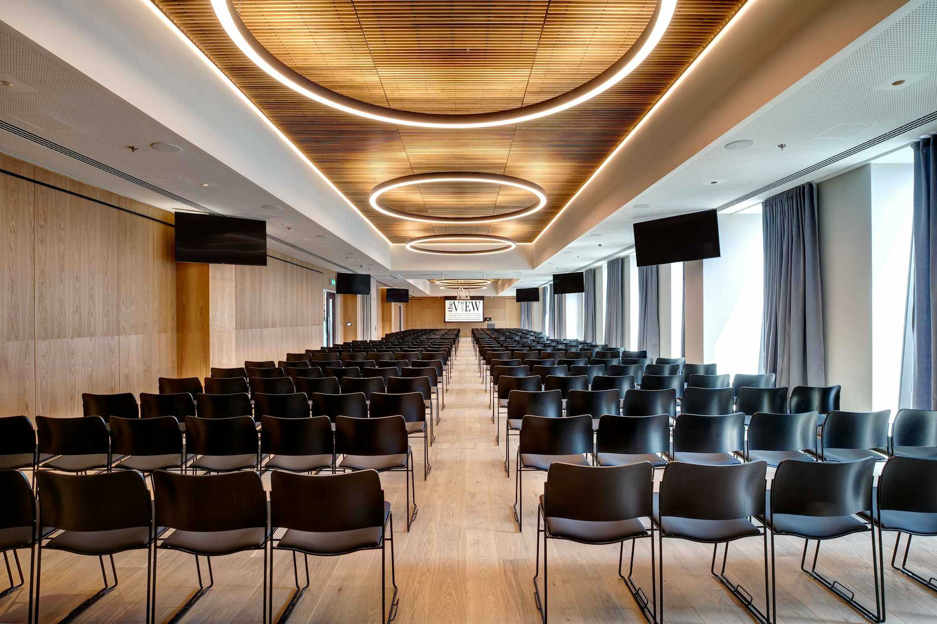 Modern conference room with theater seating for corporate presentations and seminars.