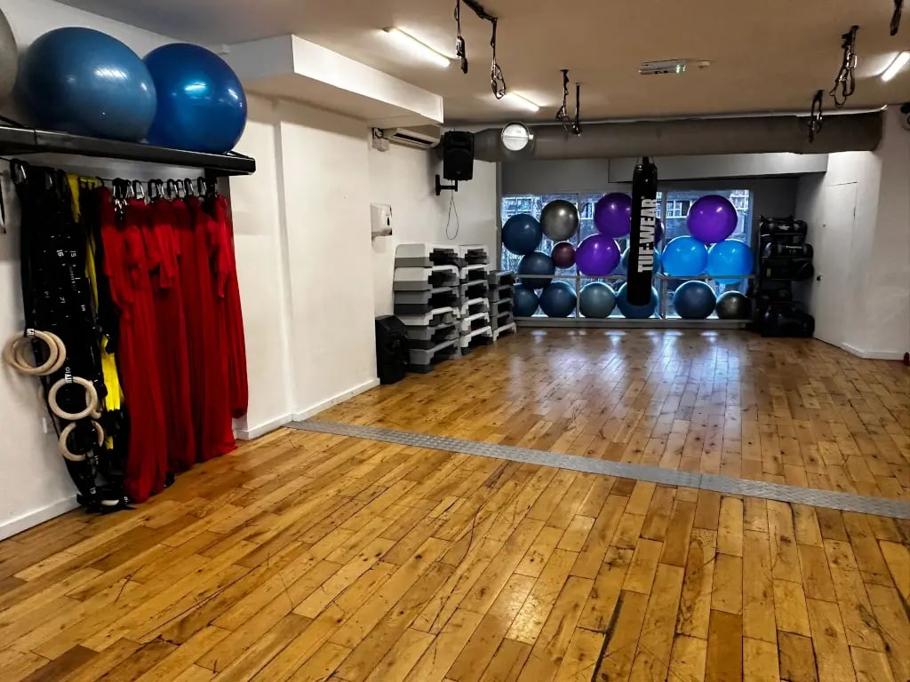 Open-plan warehouse event space with rustic floors, ideal for wellness workshops and sessions.