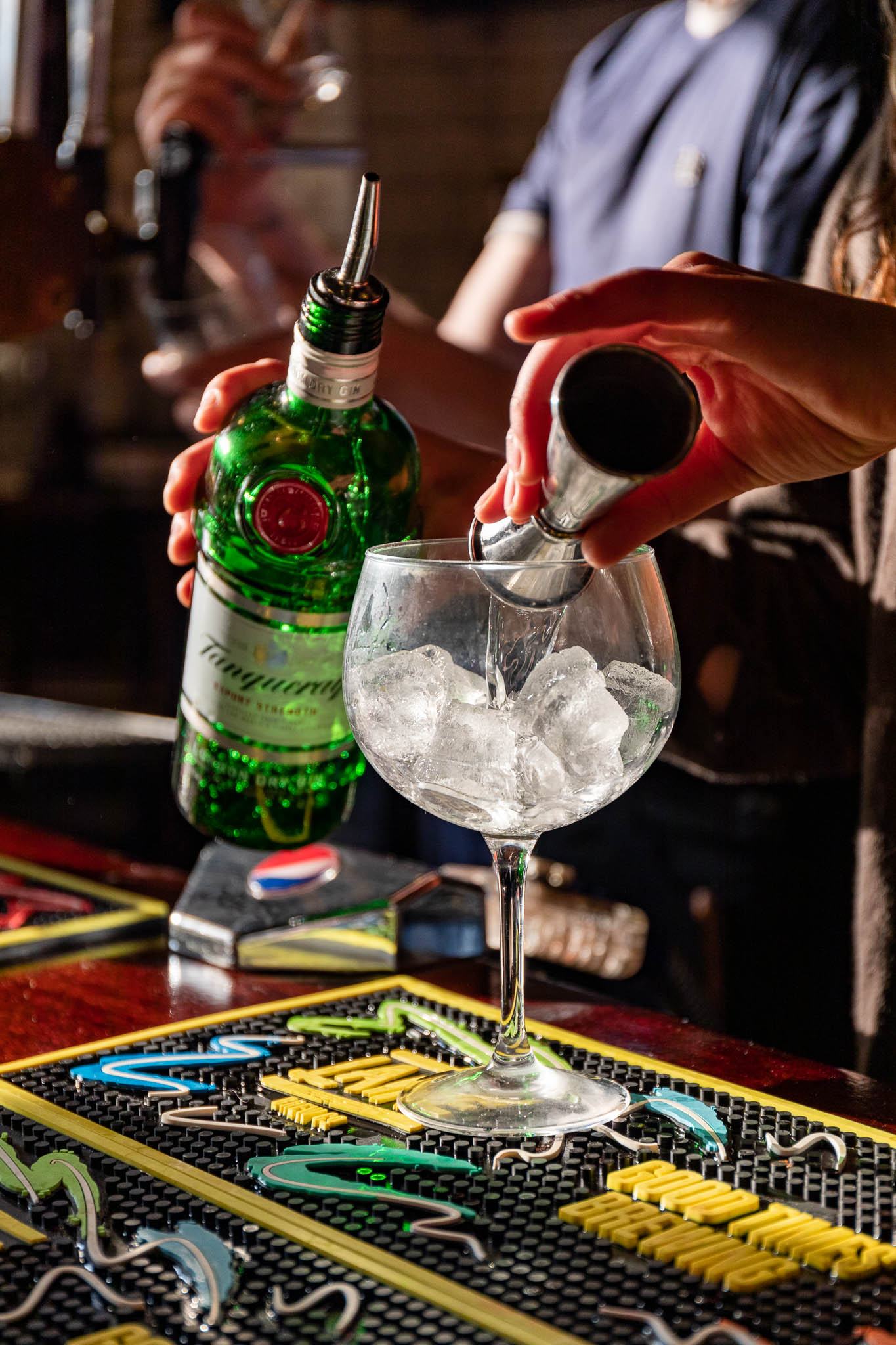 Bartender pouring gin in upscale Function Room at Inn on the Square for events.