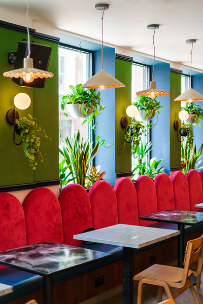 Vibrant meeting space with plush red seating at Selina UK Power Plant for networking events.