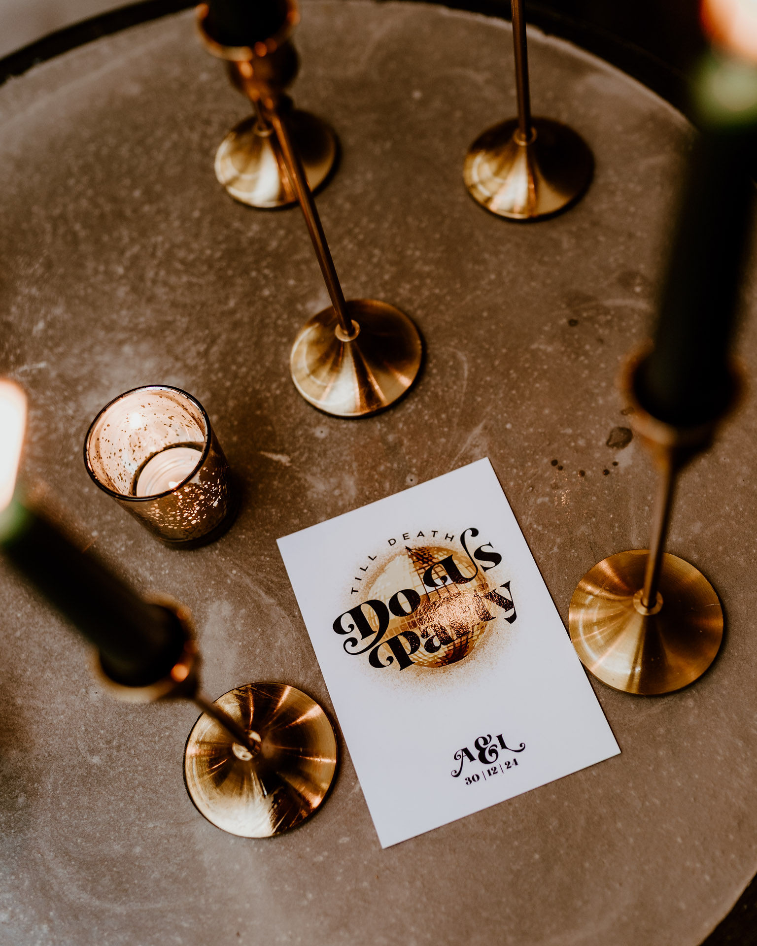 Elegant "Death Party" setup with gold candlesticks and warm lighting for unique events.