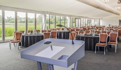 Whimbrel Marquee event space with podium, ideal for corporate conferences and gatherings.