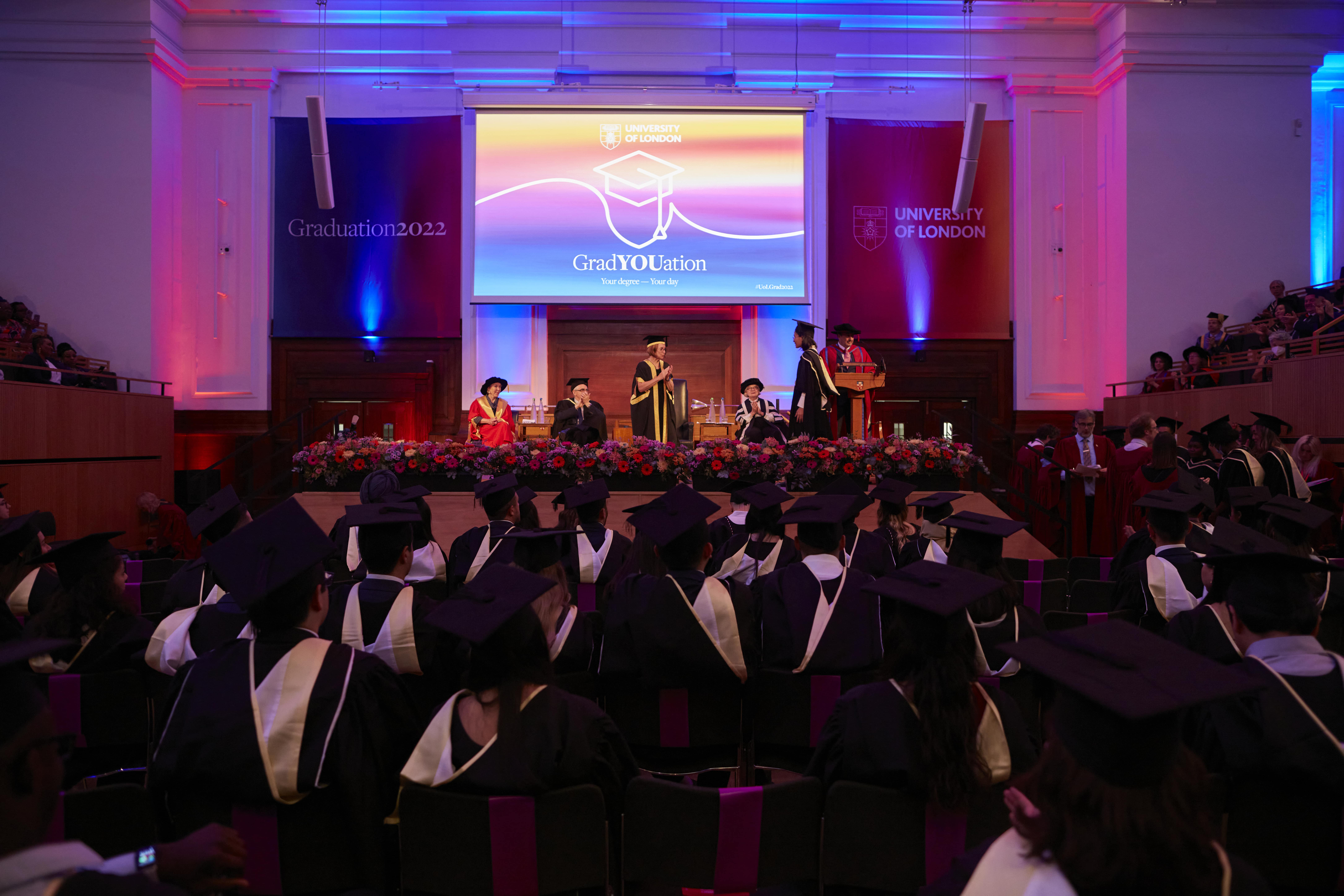 Graduation ceremony with graduates in caps and gowns, showcasing event staging and branding.