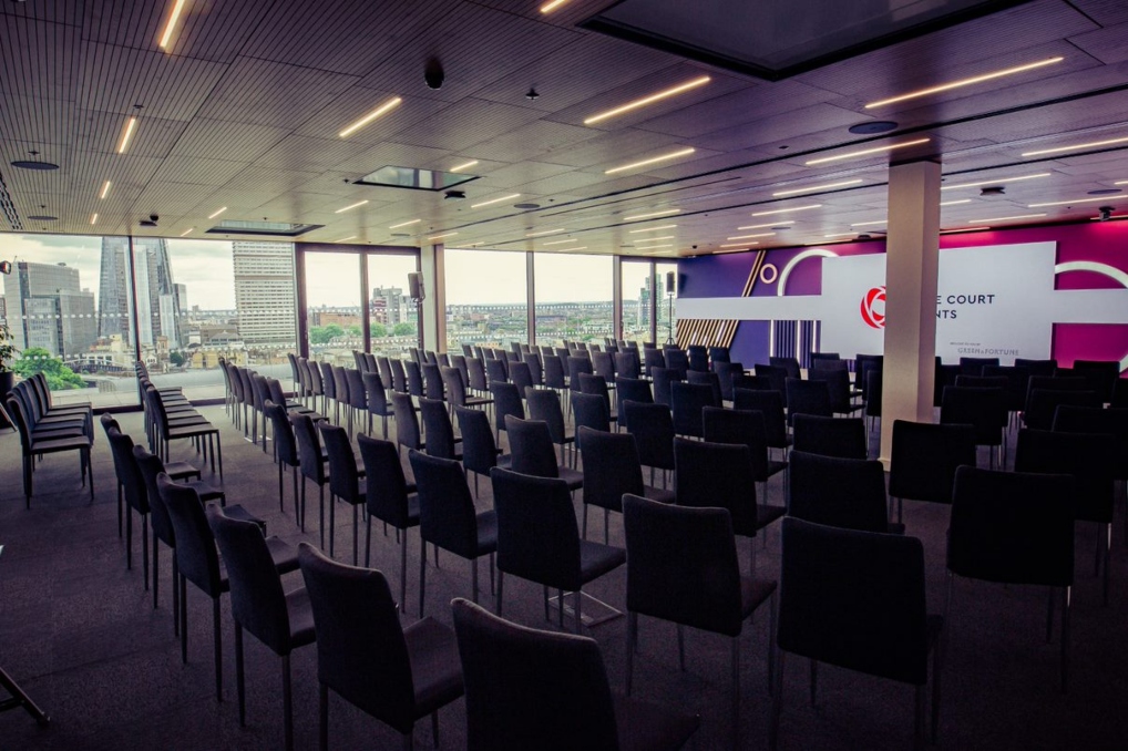Modern conference space at Rose Court Events with cityscape backdrop and sleek chairs.