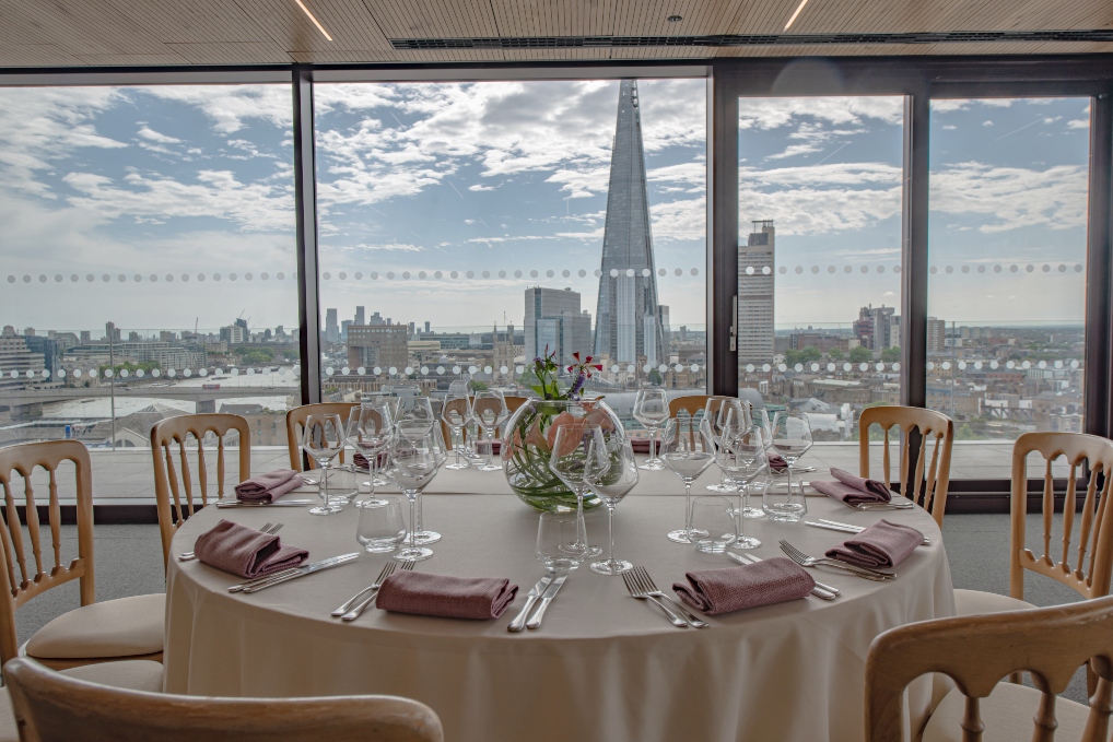 Elegant round table setup at Rose Court Events with city view, perfect for upscale meetings.