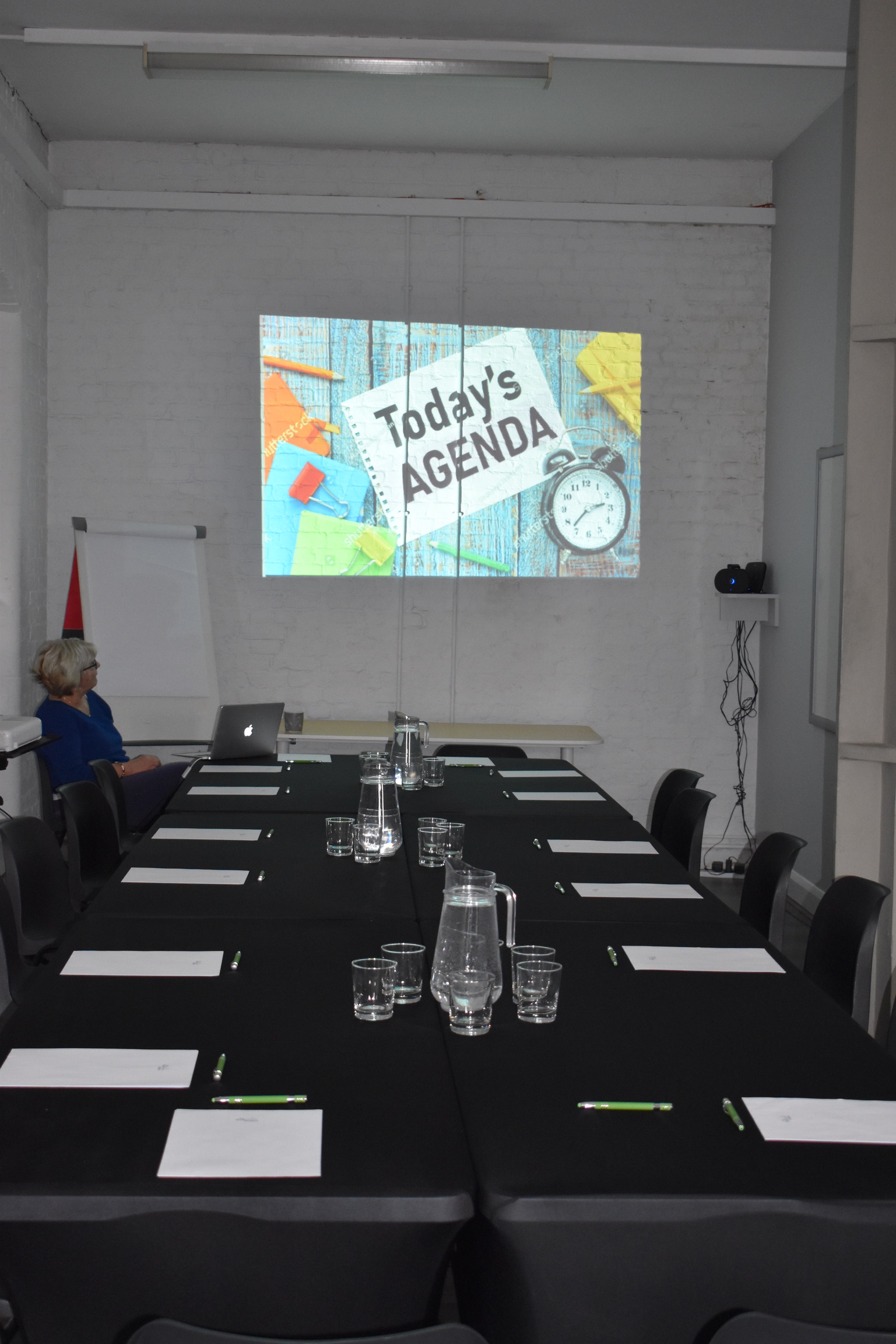 Randells Room at Boathouse Studios, organized meeting setup with agenda projection.
