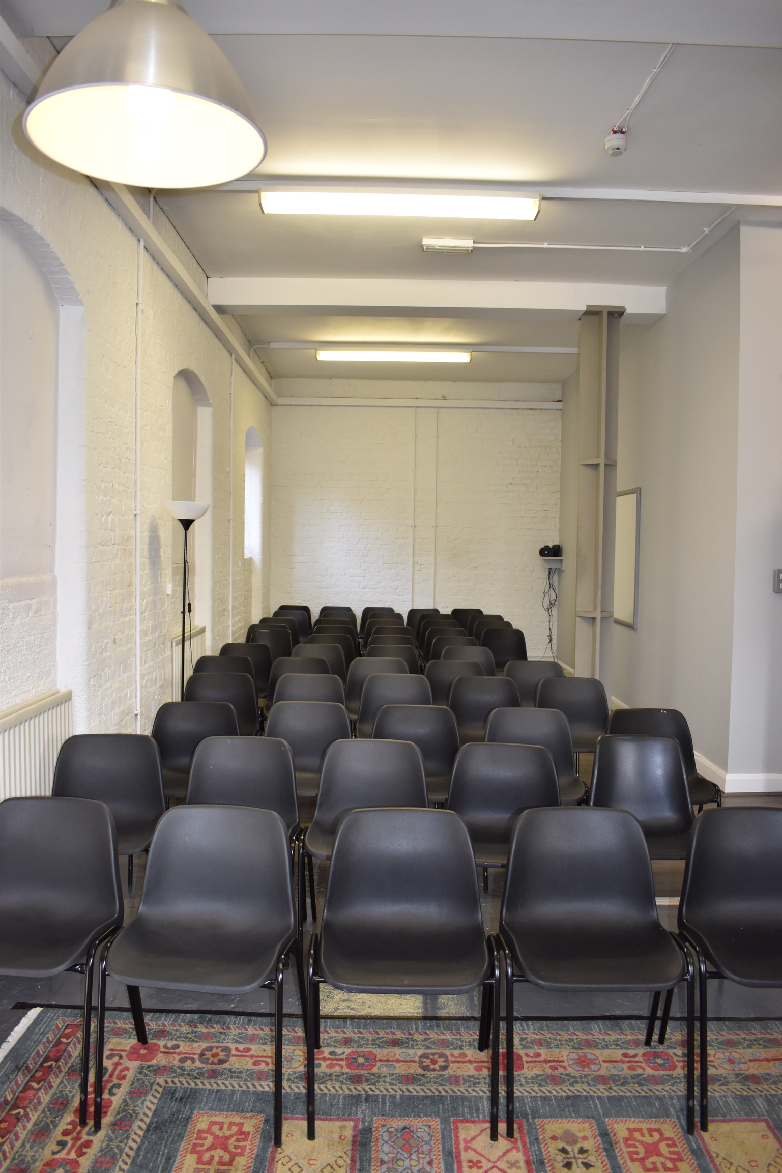 Minimalist meeting space with black chairs, ideal for workshops and presentations.