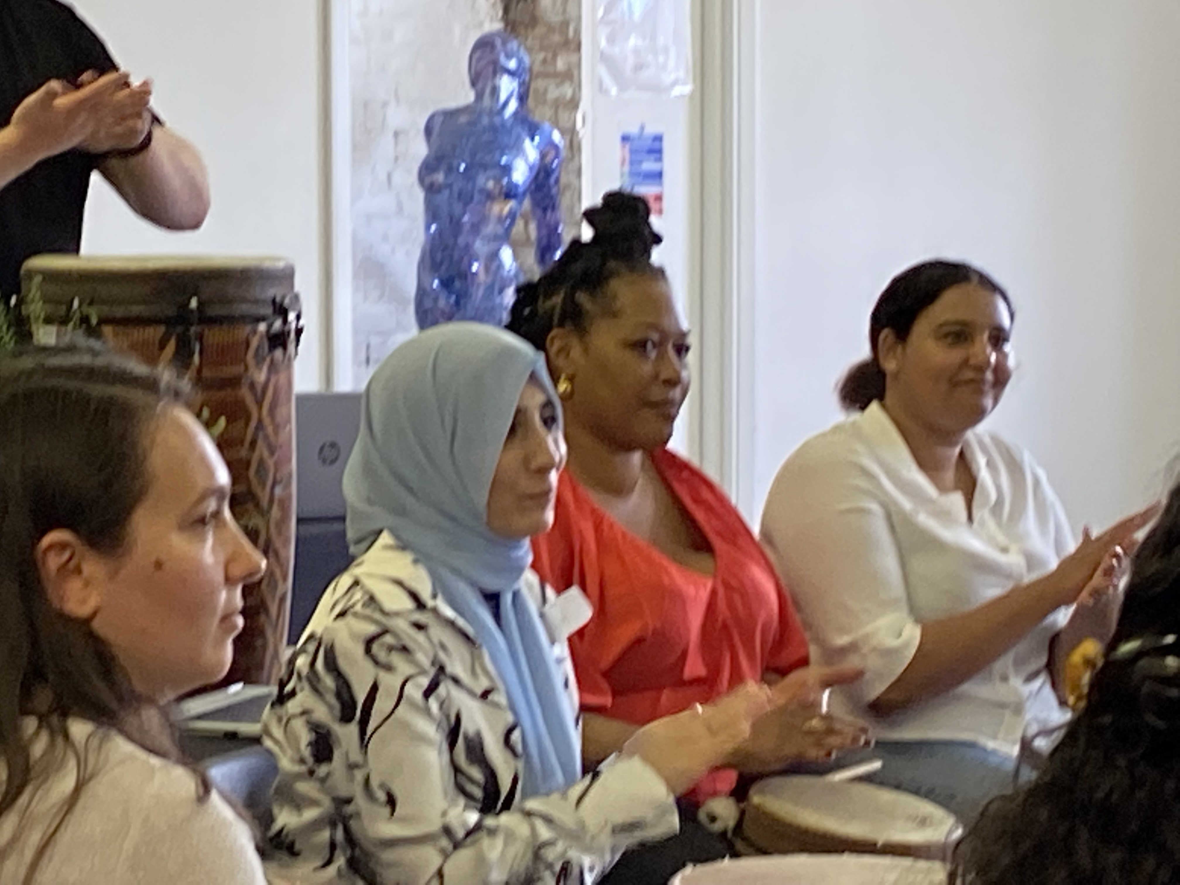 Diverse group at The Barge Aground, engaging in team-building with drums.