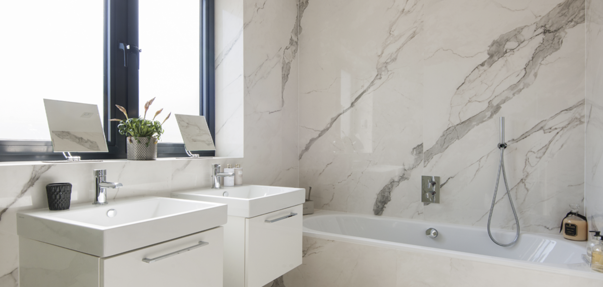 Luxury apartment bathroom with double sinks and bathtub for upscale events.