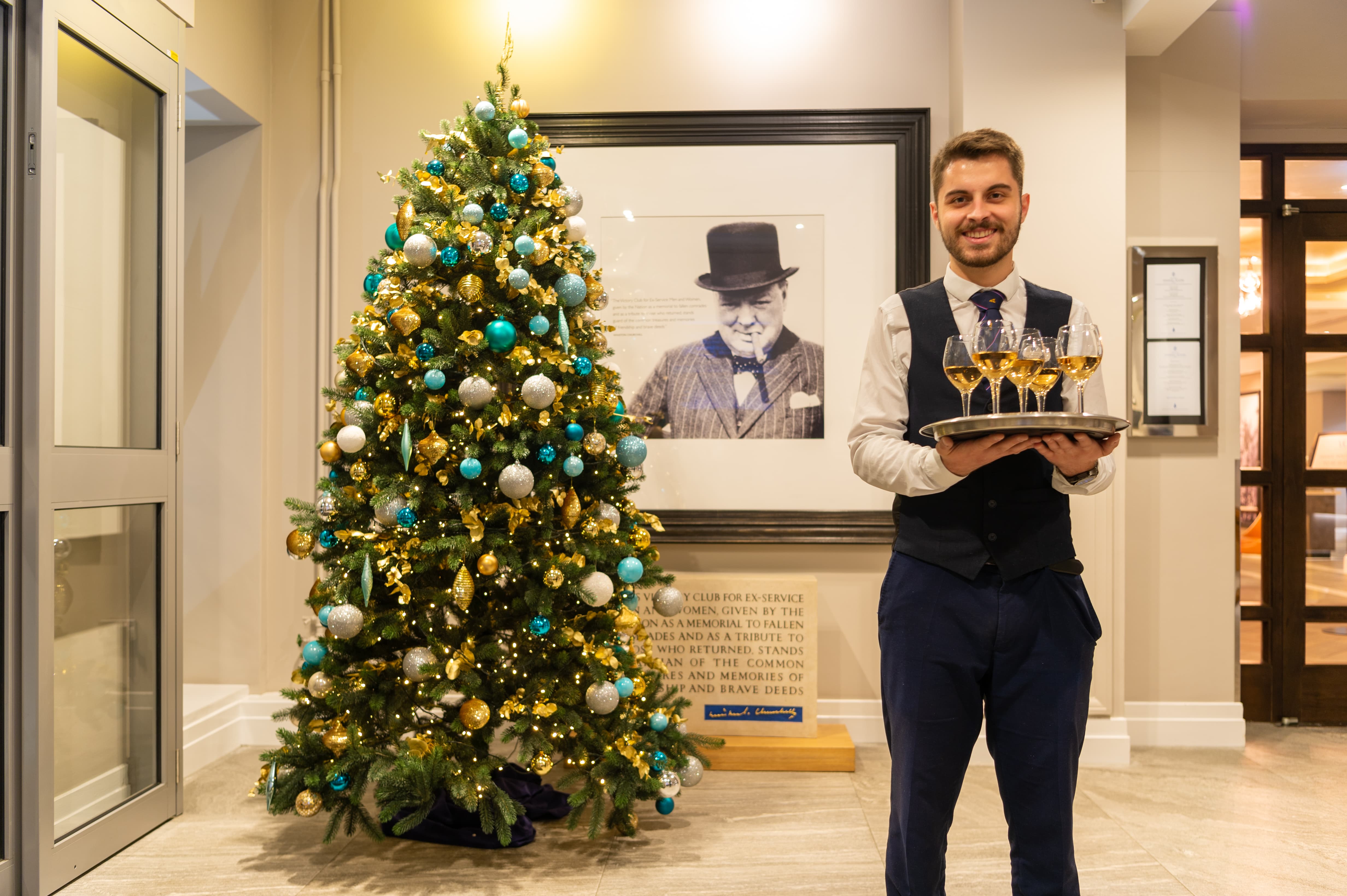 Server offering drinks at a festive Victory Services Club Christmas party event.