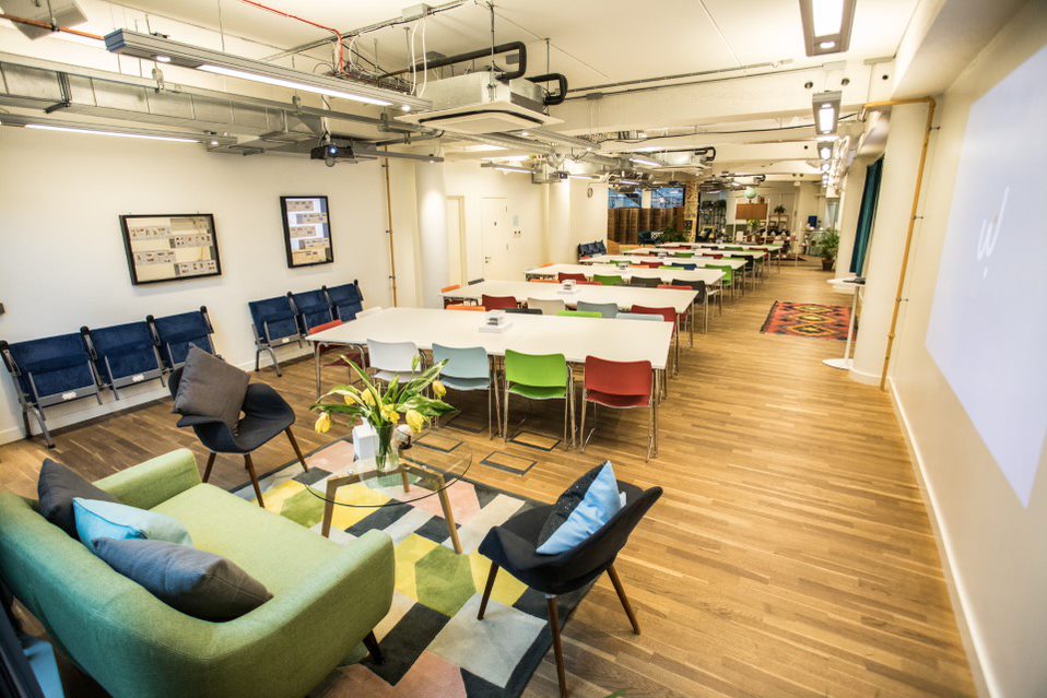 Versatile event space at The Den, colorful seating for meetings and gatherings.