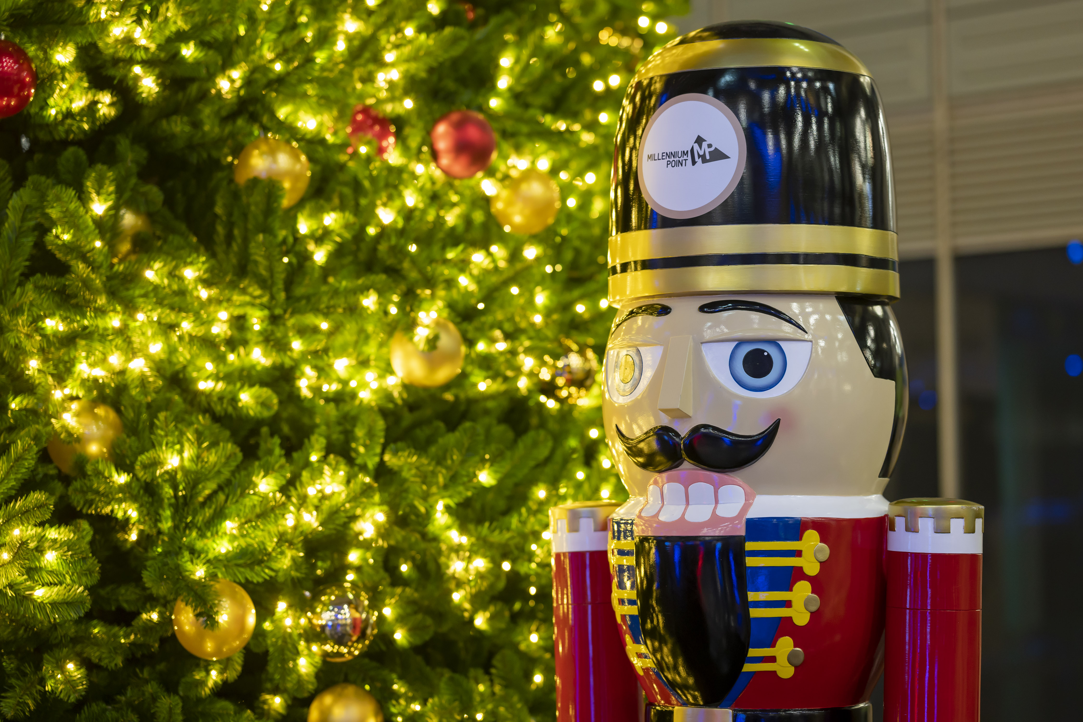 Nutcracker by Christmas tree at Millennium Point for festive corporate celebrations.